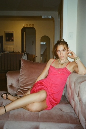 Editorial portrait in a pink dress on a velvet sofa